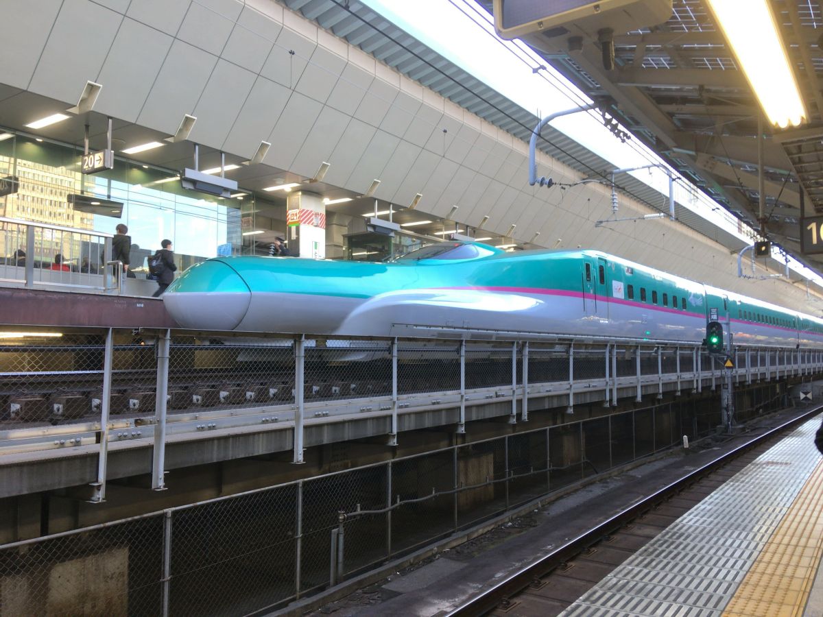 東京駅の在来線ホームから見たE5系新幹線の先頭部の写真です。斜め上の角度で写っています。